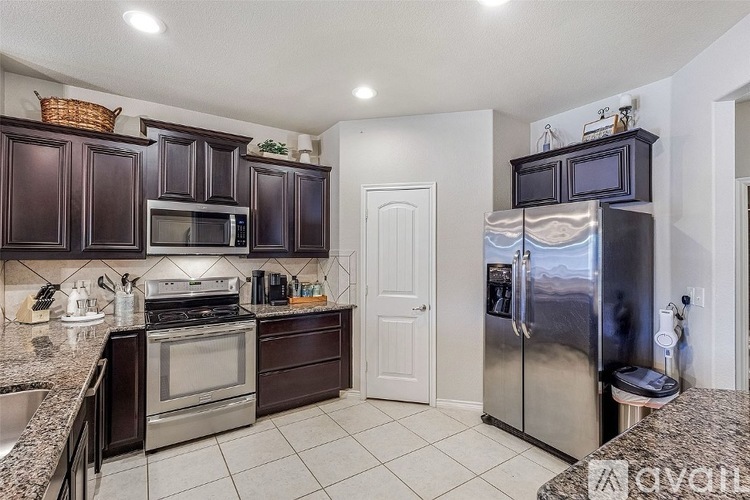 A kitchen with dark brown cabinets and stainless steel appliances.