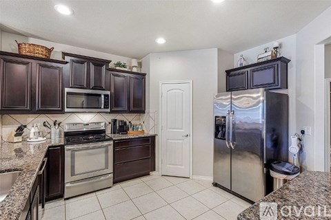 A kitchen with dark brown cabinets and stainless steel appliances.