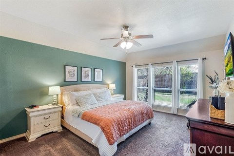 A bedroom with a bed, nightstand, and a ceiling fan.