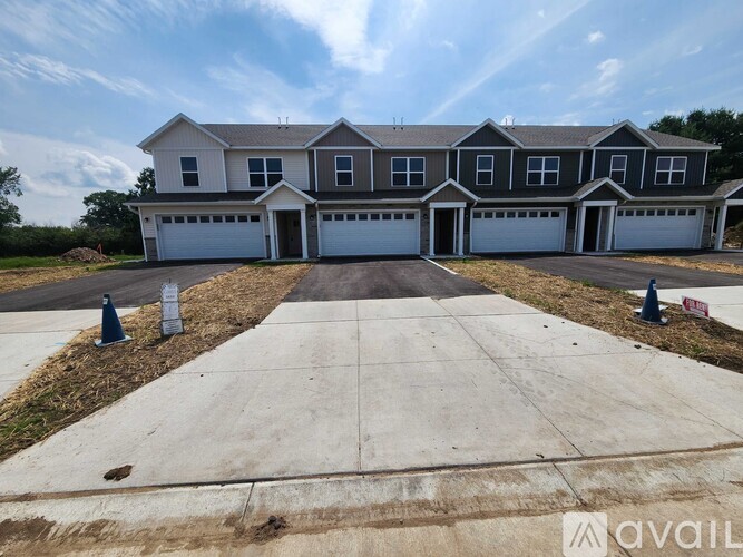 A large house with a grey roof and multiple garages.