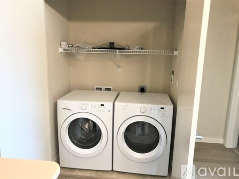 Two front loading washing machines in a small laundry room.