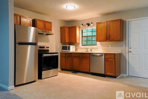 A kitchen with wooden cabinets and stainless steel appliances.