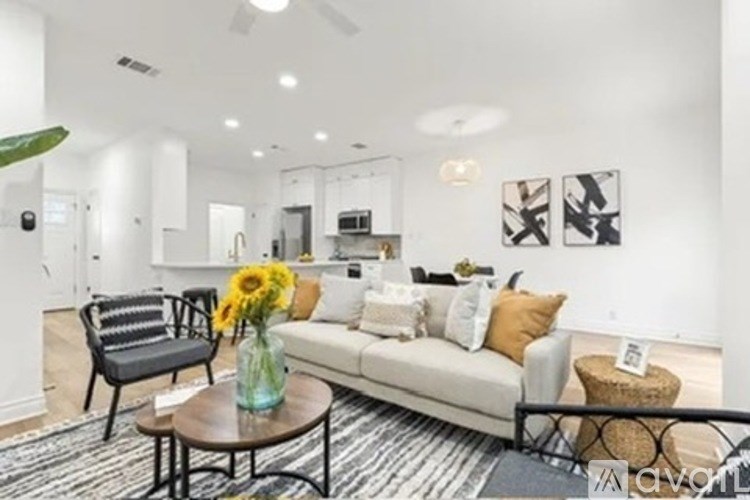 A living room with a white couch, a coffee table, and a ceiling fan.