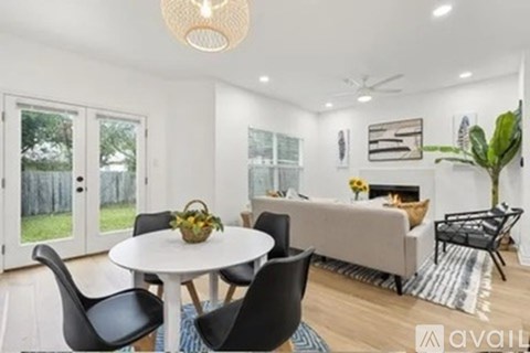 A modern living room with a dining table and chairs.
