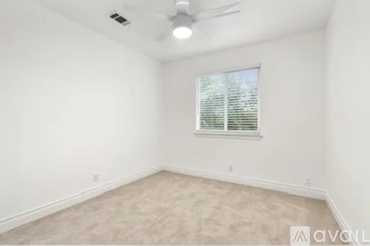 A room with a window and a fan on the ceiling.