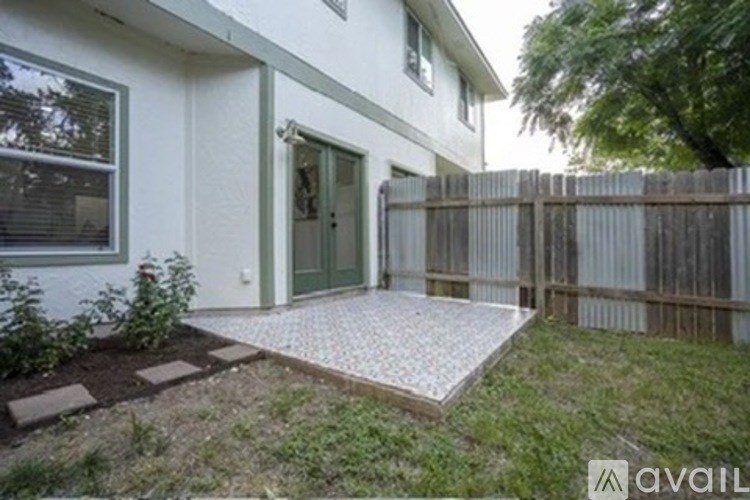 A white house with a green door and a wooden fence.