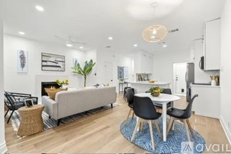 A modern living room with a grey sofa, a white coffee table, and a blue rug.
