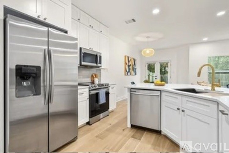 A modern kitchen with stainless steel appliances and white cabinets.