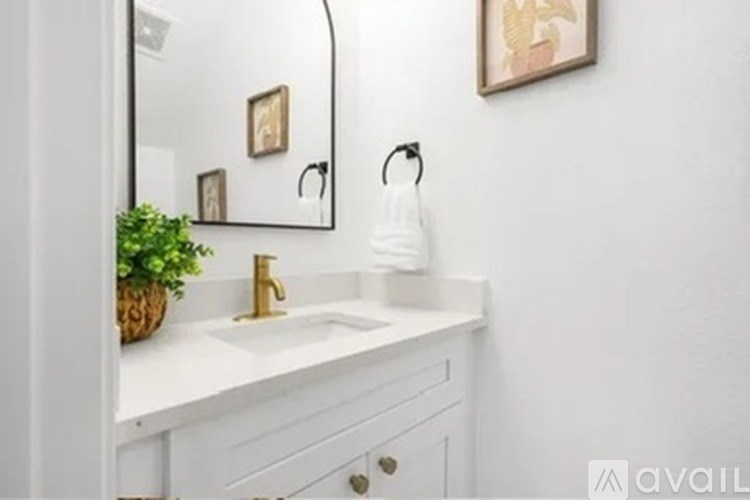 A bathroom with a white sink and a mirror above it.