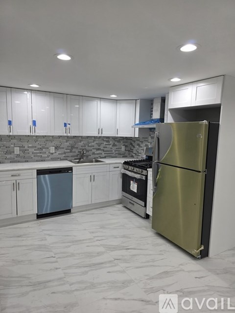 A kitchen with a refrigerator, dishwasher, and oven.