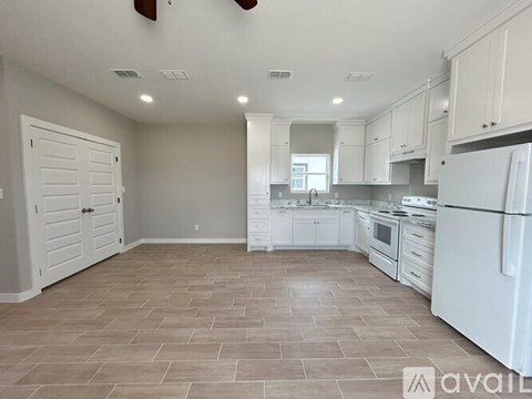 A kitchen with white appliances and cabinets.