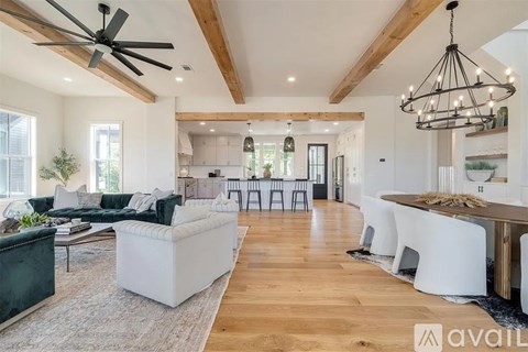 A spacious living room with a dark green sofa and a white coffee table.