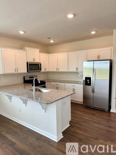 A kitchen with a granite countertop and stainless steel appliances.