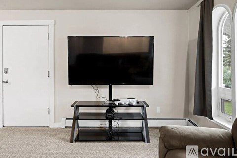 A black television is on a stand in a living room.
