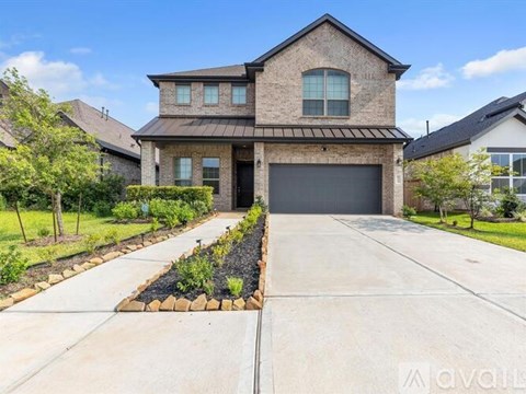 A house with a driveway and landscaping in front.