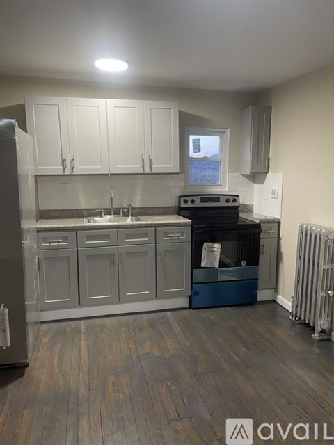 A kitchen with a black oven and white cabinets.