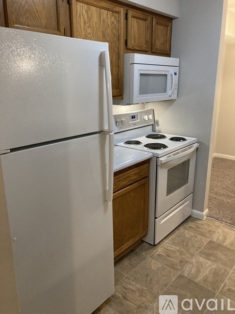 A kitchen with a white refrigerator, a white microwave, and a white stove top oven.