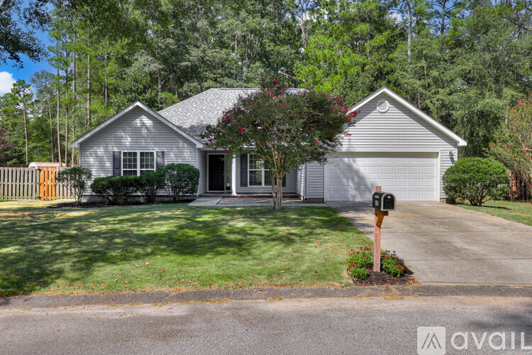 A house with a green lawn and trees in the background.