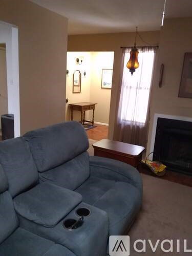 A grey sofa with sunglasses on it in a living room.