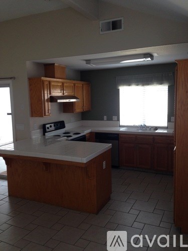 A kitchen with a white countertop and wooden cabinets.