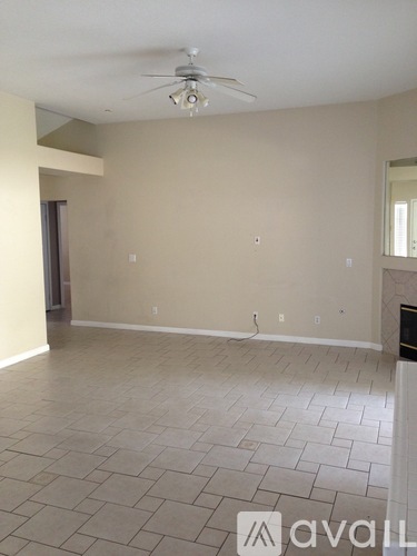 A room with a ceiling fan and tile flooring.