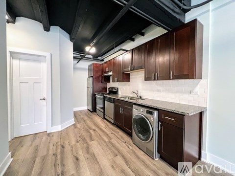 A kitchen with wooden cabinets and a white door.
