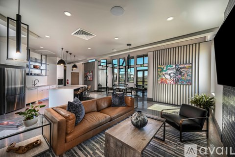 A modern living room with a brown leather couch and a glass coffee table.