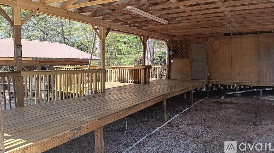 A wooden deck with a roof and railings is under construction.