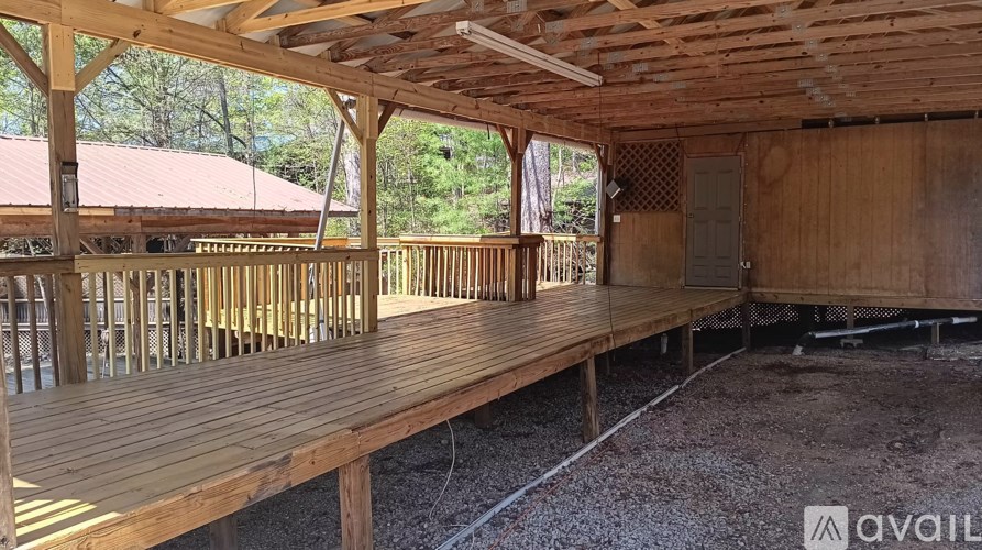 A wooden deck with a roof and railings is under construction.