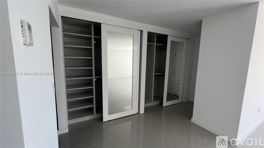 A white room with a white door and a white wall.