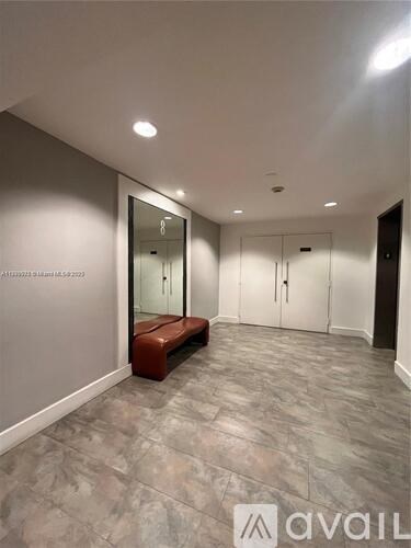 A hallway with a bench and a mirror on the wall.