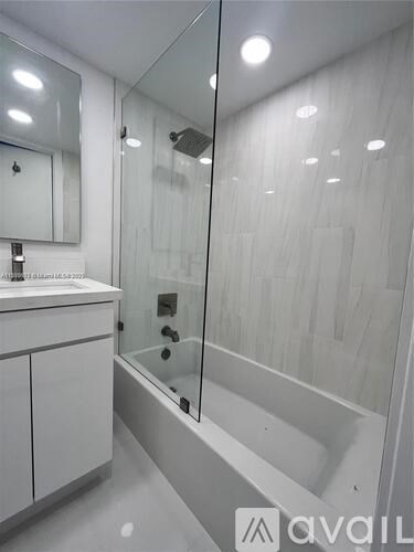 A modern bathroom with a walk-in shower and a vanity with a mirror.