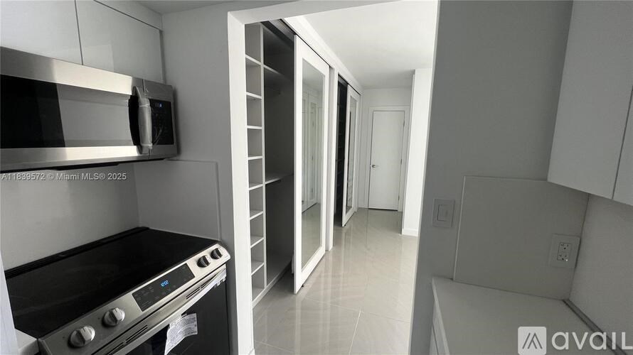 A kitchen with a stove, oven, microwave, and a ladder.