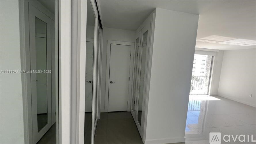 A hallway with white walls and a door on the right.