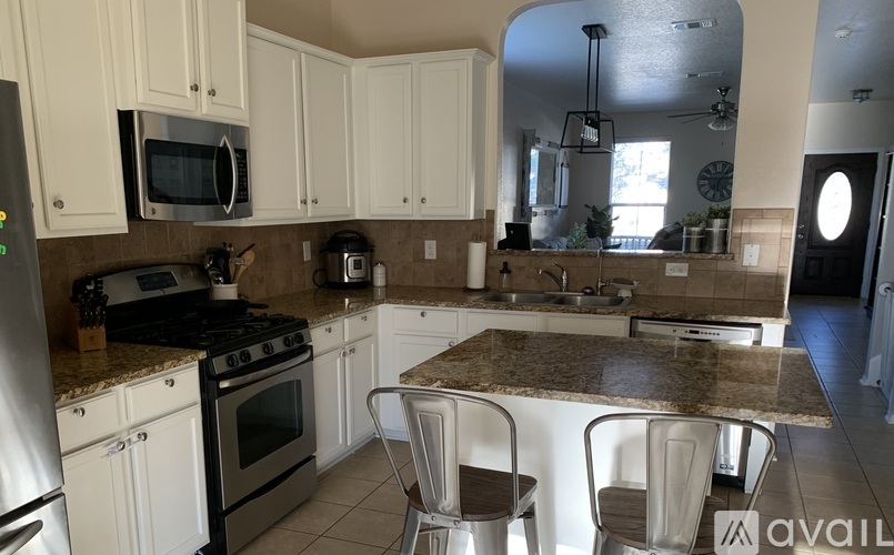 A kitchen with white cabinets and a granite countertop.
