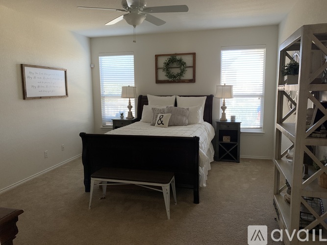 A bedroom with a bed, a chair, and a wreath on the wall.