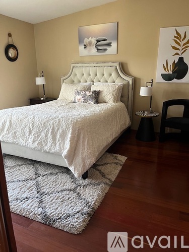 A bedroom with a large bed and a white headboard.