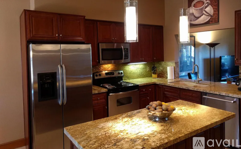 A kitchen with a granite countertop and stainless steel appliances.