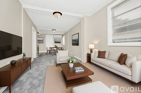 A living room with a white couch and a wooden coffee table.