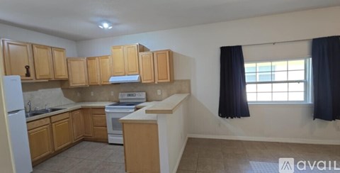 A kitchen with wooden cabinets and a white refrigerator.
