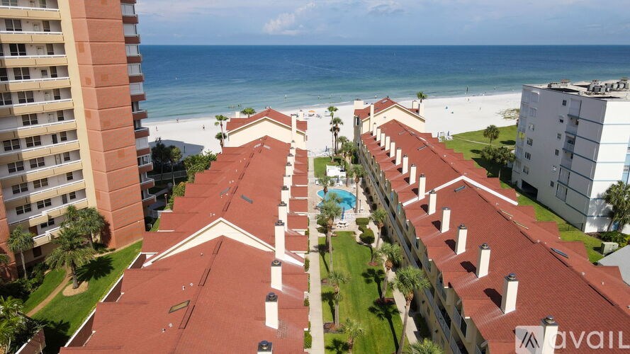 A beachfront apartment complex with a pool and a view of the ocean.
