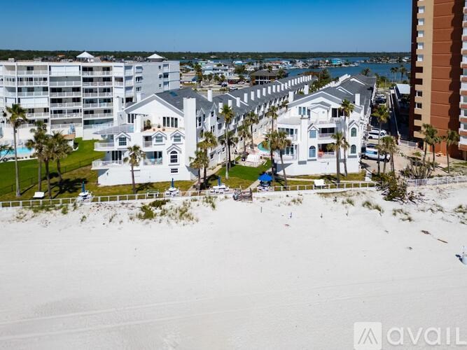 A beachfront property with a pool and a building in the background.