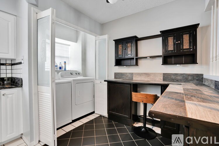 A kitchen with black and white tiles and wooden countertops.