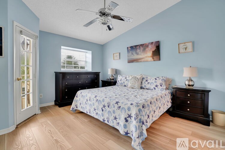 A bedroom with a bed, dresser, and ceiling fan.