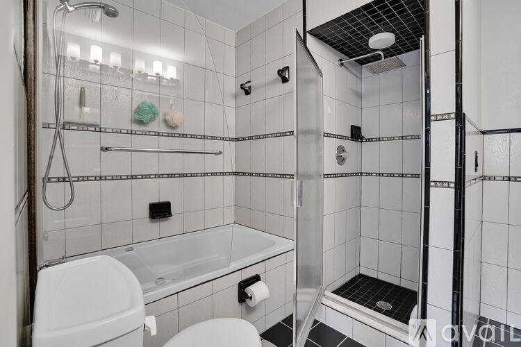 A white toilet is in a small bathroom with a walk-in shower.