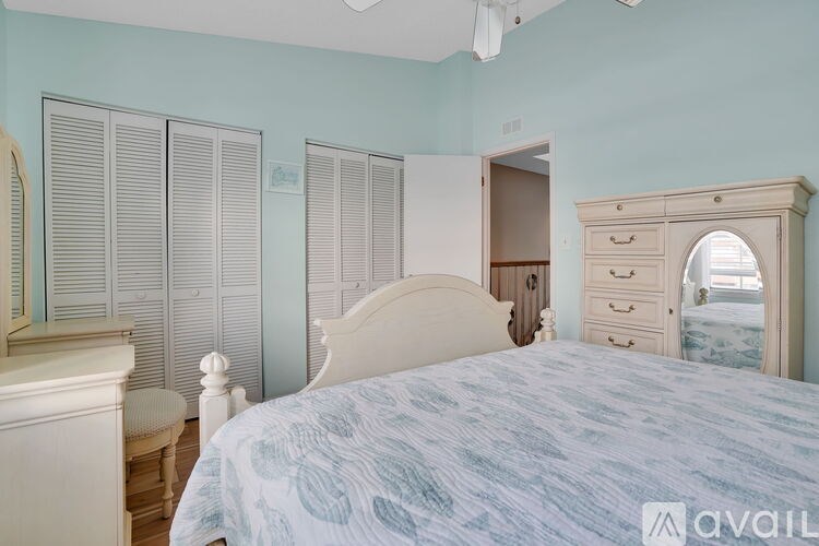 A bedroom with a bed, dresser, and mirror.