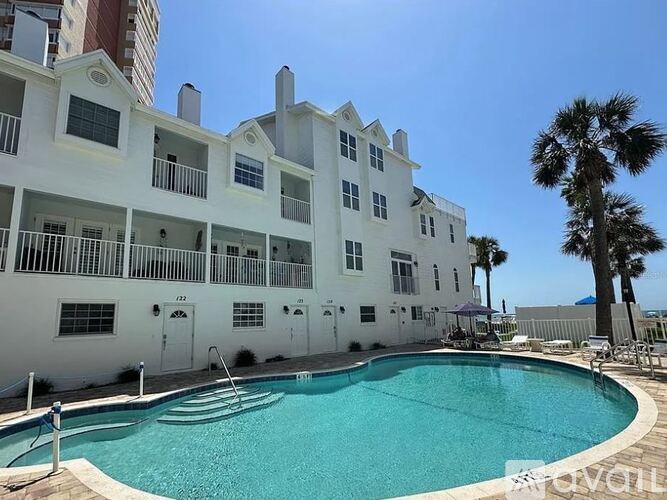 A white building with a pool in front.