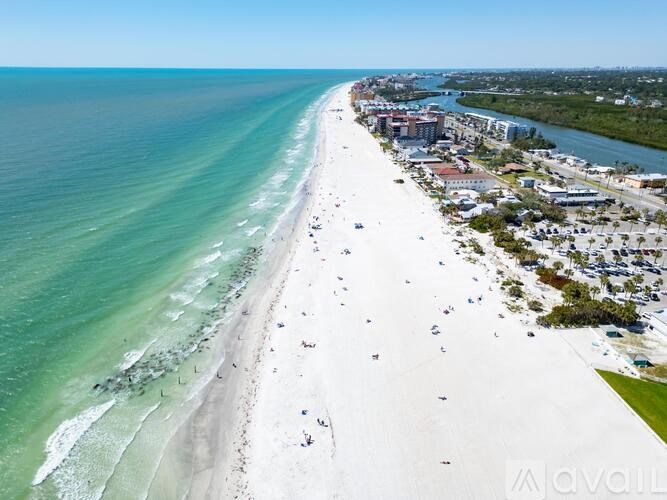 A beach with people on it and a river running through the town.
