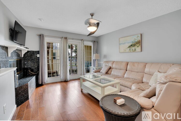 A living room with a beige couch and a glass coffee table.