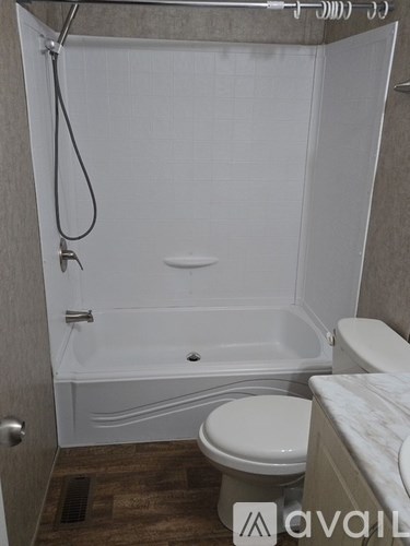 A bathroom with a white tub and toilet.